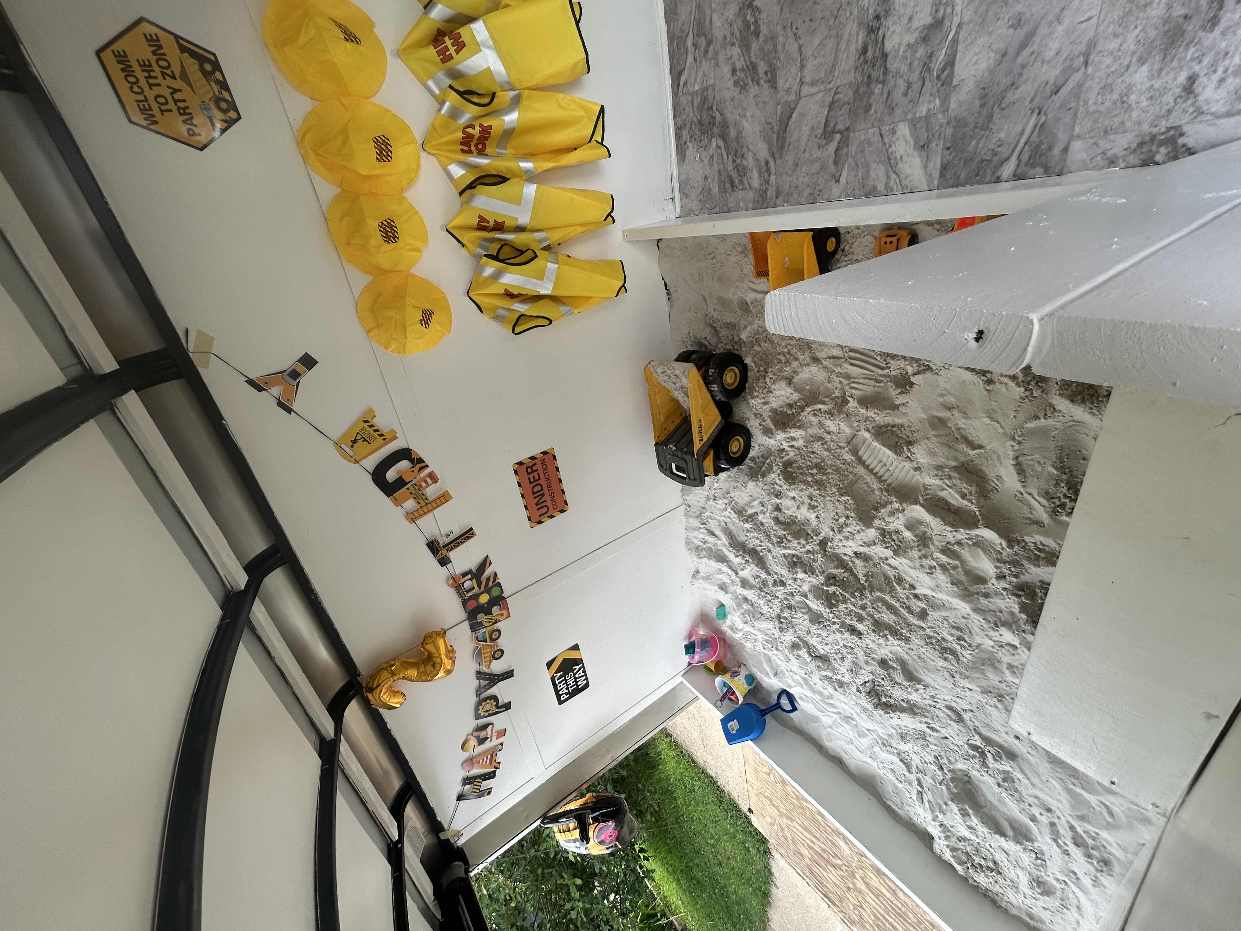 Construction theme sand play setup with birthday decorations and toys