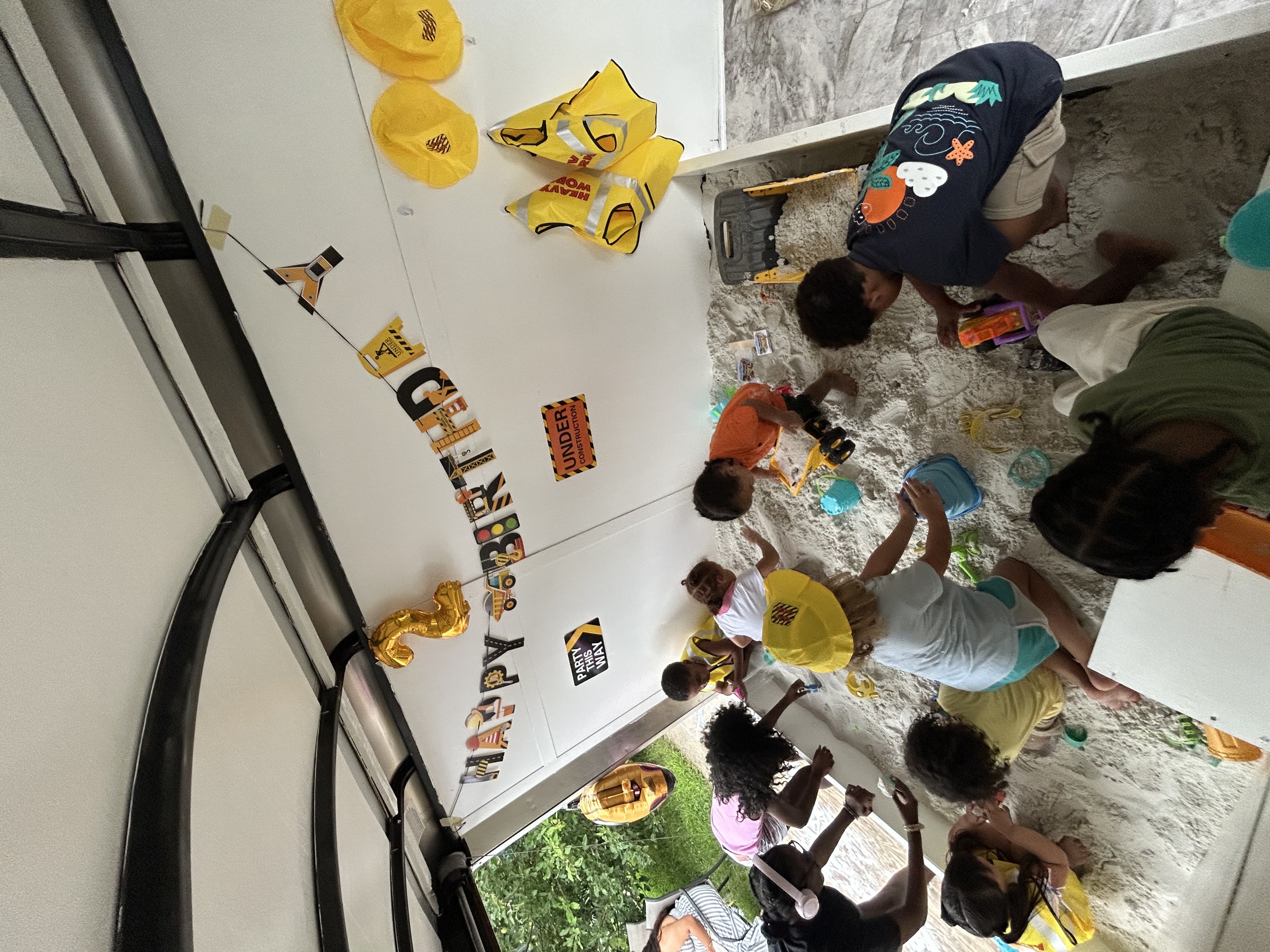 Children playing in the sand inside the Legacy Sand Adventures trailer at a birthday party